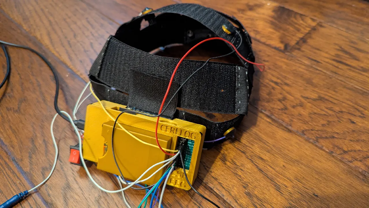 CereBRAH Soft-EEG headband with dry comb electrodes mounted on elastic and nylon webbing, connected to a Cerelog ESP-EEG board